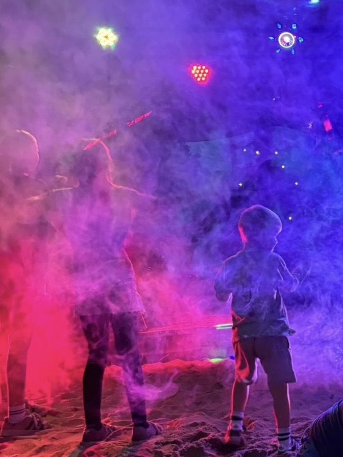 Buntes Licht und Nebel auf dem Sand bei einem Abendevent